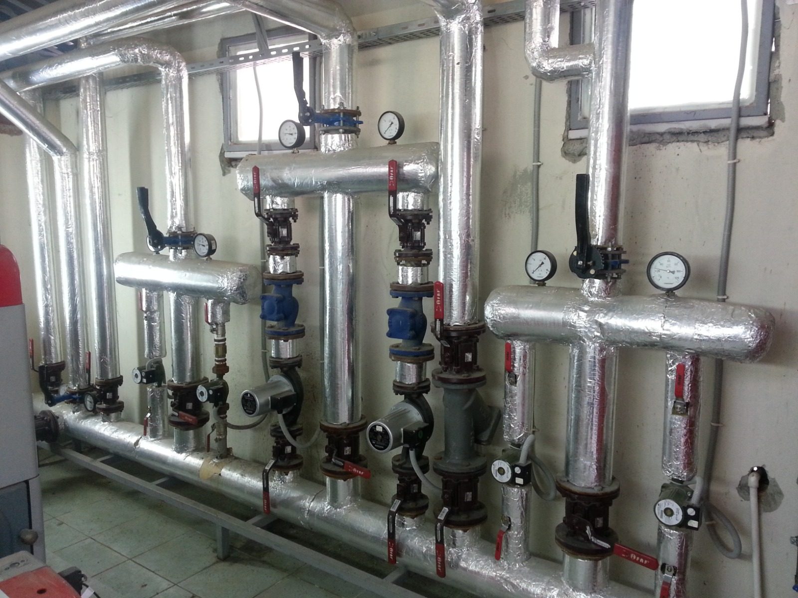 Yalıtımlı ısıtma-soğutma kolektörü ve sirkülasyon pompa grubu — HVAC mekanik tesisatı